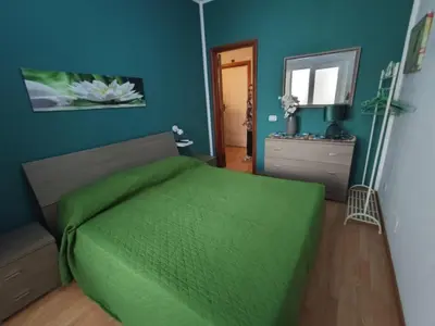 a bedroom with a green bed and a blue wall at Medea rooms palermo centro in Palermo
