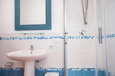 a bathroom with a sink and a toilet at Casa Orchidea Bianca in San Vito lo Capo