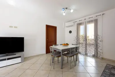 a dining room with a table and chairs and a television at Bedda Luna Villa in San Vito lo Capo