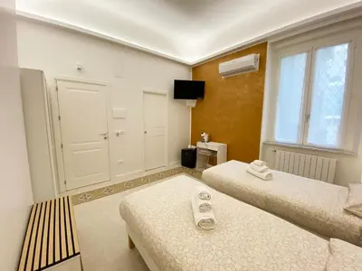 a small room with two beds and a window at Casa Granatelli in Palermo