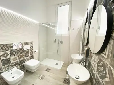 a bathroom with two toilets and a sink and a shower at Casa Granatelli in Palermo