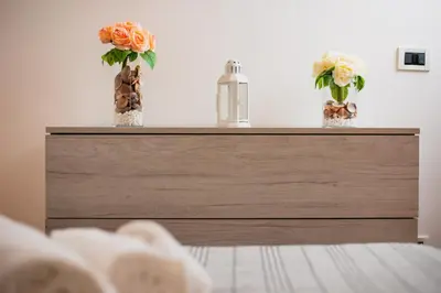 two vases with flowers on top of a dresser at VILLA HEMINGWAY - LA Casa di Alessia e La Casa di Leonardo in Ficarazzi