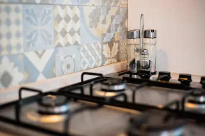 a stove top in a kitchen next to a wall at VILLA HEMINGWAY - LA Casa di Alessia e La Casa di Leonardo in Ficarazzi