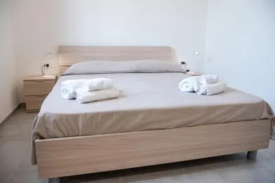 a bedroom with a bed with two towels on it at Villa Marica in Partinico