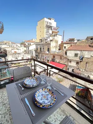 a table with two plates of food on a balcony at Bella Vita Palermo in Palermo