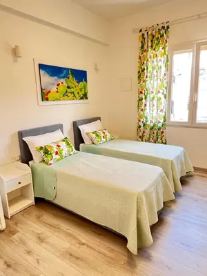 two beds in a room with a window at Bella Vita Palermo in Palermo