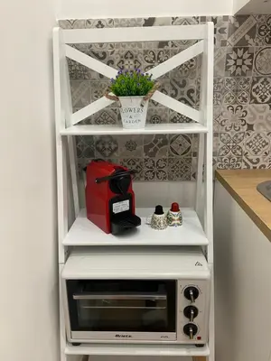 a white shelf with a microwave in a kitchen at La Piccola Formica Home in Palermo