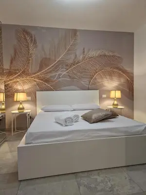 a bedroom with a large white bed with two lamps at Villa Fragi in Cinisi