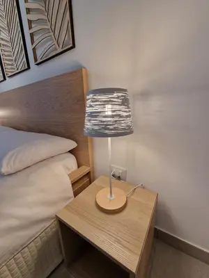a lamp on a table next to a bed at Villa Fragi in Cinisi