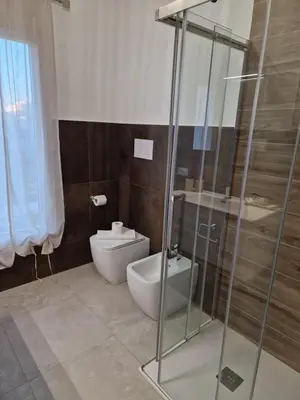 a bathroom with a toilet and a glass shower at Villa Fragi in Cinisi