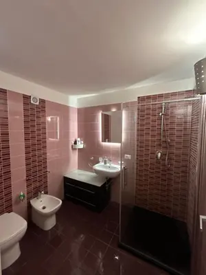 a bathroom with a toilet and a sink and a shower at Prince Suite Palermo in Palermo