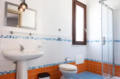 a bathroom with a toilet and a sink at Casa Orchidea Nera in San Vito lo Capo