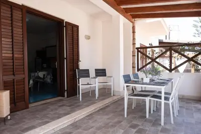 a patio with a table and chairs on a patio at Casa Orchidea Nera in San Vito lo Capo