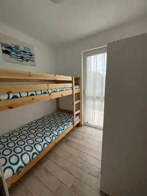 a bedroom with two bunk beds and a window at Casa Vacanze Isabella in Campofelice di Roccella