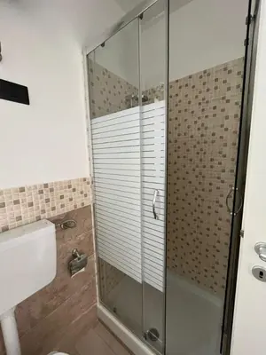 a bathroom with a shower with a glass door at Casa Vacanze Isabella in Campofelice di Roccella