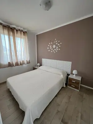 a bedroom with a large white bed and a lamp at Casa Vacanze Isabella in Campofelice di Roccella
