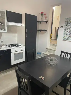 a kitchen with a black table with chairs and a stove at Zohra in Castellammare del Golfo