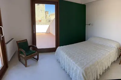 a bedroom with a bed and a chair and a window at Palazzo Triolo - Dimora di Charme in Corleone