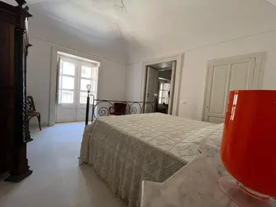 a bedroom with a bed in a white room at Palazzo Triolo - Dimora di Charme in Corleone