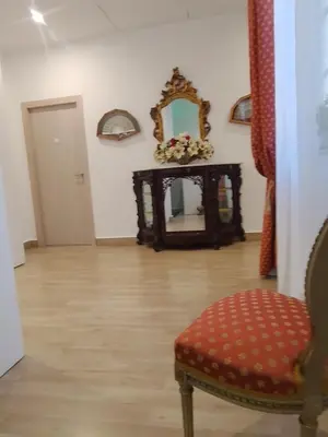 a living room with a chair and a mirror at LE CAMERE DI VIA MECCIO in Palermo