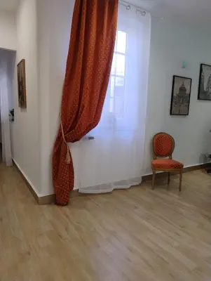 a room with a curtain and a chair and a window at LE CAMERE DI VIA MECCIO in Palermo