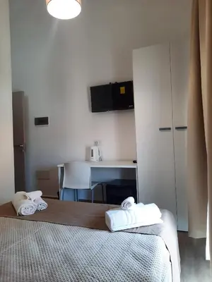 a bedroom with a bed and a desk with a microwave at LE CAMERE DI VIA MECCIO in Palermo