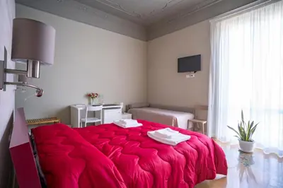 a bedroom with a red bed with a red blanket at B&B Handy Palermo in Palermo