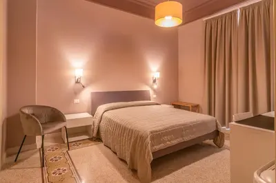 a bedroom with a bed and a desk and a chair at B&B Handy Palermo in Palermo