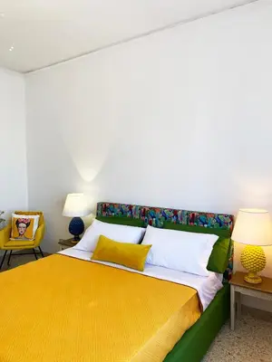 a bedroom with a large bed with a yellow blanket at Casa Graziusa in Palermo