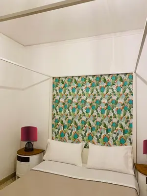 a bedroom with a bed with a floral curtain behind it at Casa Graziusa in Palermo