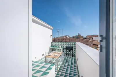 a balcony with a table and chairs on a roof at Porta di Castro Design Apartment with Terrace by Wonderful Italy in Palermo
