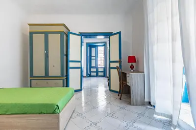 a bedroom with a bed and a table and a desk at Piazza Pretoria & Quattro Canti Roomy Flats with Balconies in Palermo