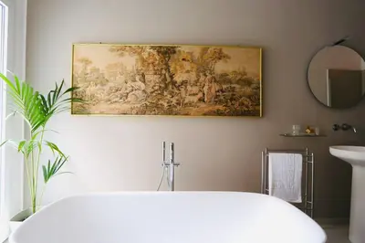 a bathroom with a painting on the wall and a tub at Guest House Colonna in Palermo