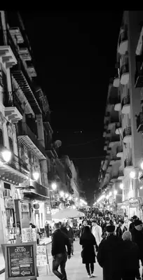 a group of people walking down a street at night at Energy Home in Palermo