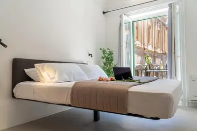 a bedroom with a bed with a laptop on it at Eligius Luxury Apartments in Palermo
