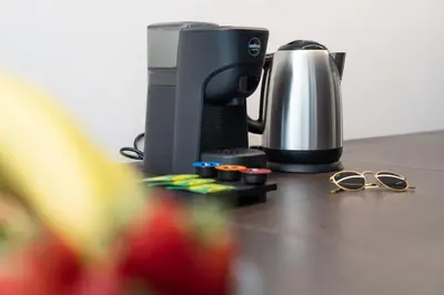 a coffee maker and glasses on a table at Eligius Luxury Apartments in Palermo