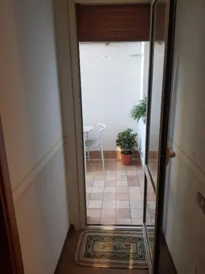 a hallway with a glass door leading to a room with a table at Casa Milù in Palermo