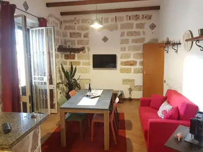 a living room with a table and a red couch at Casa Milù in Palermo