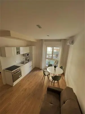 a kitchen and a living room with a table and chairs at wood & white home in Palermo