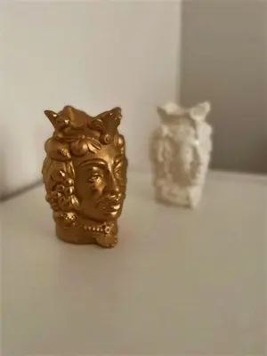 a couple of gold statues sitting on a table at wood & white home in Palermo