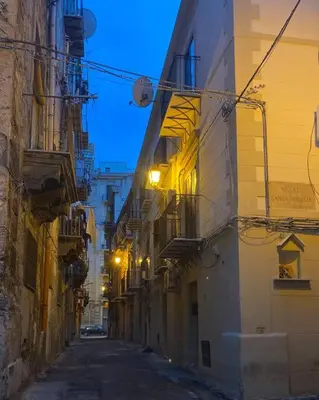 an alley with buildings and street lights at night at Residenza dei Tartari - Historic center in Palermo