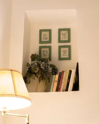 a shelf with books and a vase with a plant on it at Casa Madì in Palermo