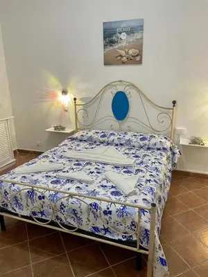 a bedroom with a bed with a blue and white comforter at Ninni Mondello House in Mondello