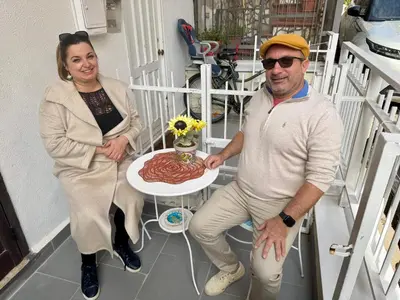 a man and a woman standing next to a table with a cake at Ninni Mondello House in Mondello