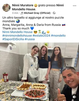 a group of people standing next to a table with food at Ninni Mondello House in Mondello