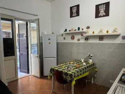 a kitchen with a table and a refrigerator at Ninni Mondello House in Mondello
