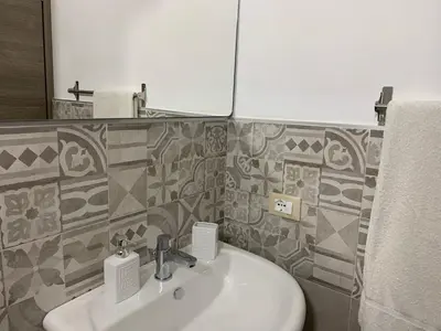 a bathroom with a sink and a mirror at La Villa degli Ulivi - Apartments in Castellammare del Golfo