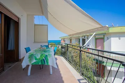 a balcony with a table and chairs and the ocean at Sea Air - Aria di Mare in Casteldaccia