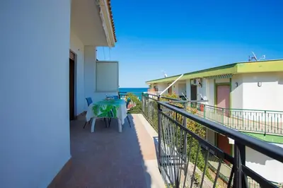 a balcony with a table and a view of the ocean at Sea Air - Aria di Mare in Casteldaccia