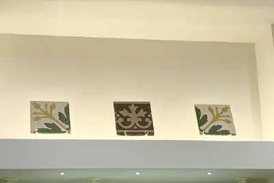 a shelf with four tiles on a wall at Sikelia Apartment Centro in Palermo